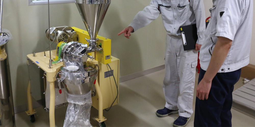 今回更新したホッパー部品をセットした紛砕機を指差す